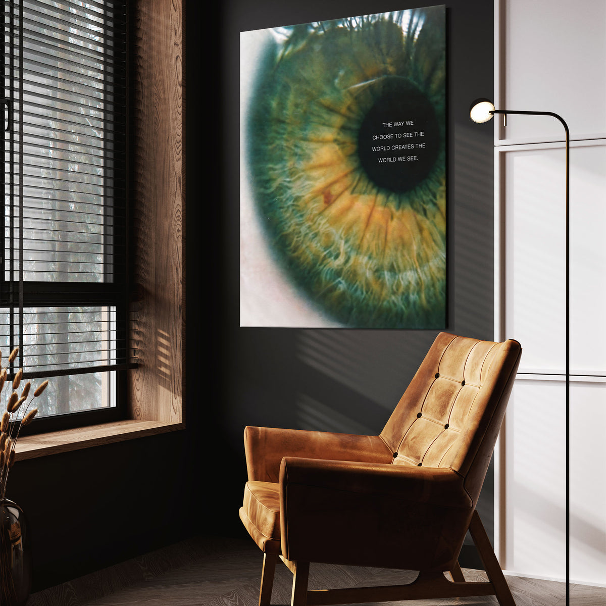 A Matter of Perspective green and gold eye wall art above a tan chair in a dark reading corner
