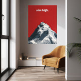 Aim High wall art above a mustard chair in a bright room