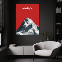 Aim High wall art above a white chair in a dark room