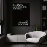 Balance quote wall art above a white chair in a dark room