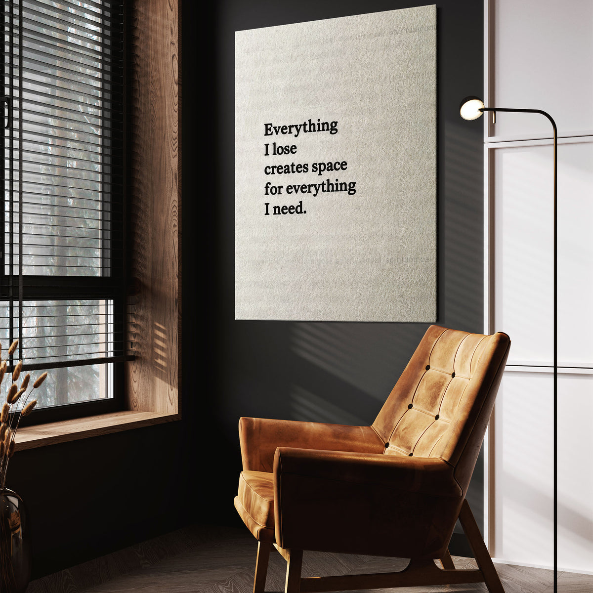 Everything I Lose quote wall art above a tan chair in a dark reading corner