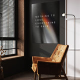 Everything To Gain motivational wall art above a tan chair in a dark reading corner