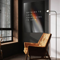 Everything To Gain motivational wall art above a tan chair in a dark reading corner