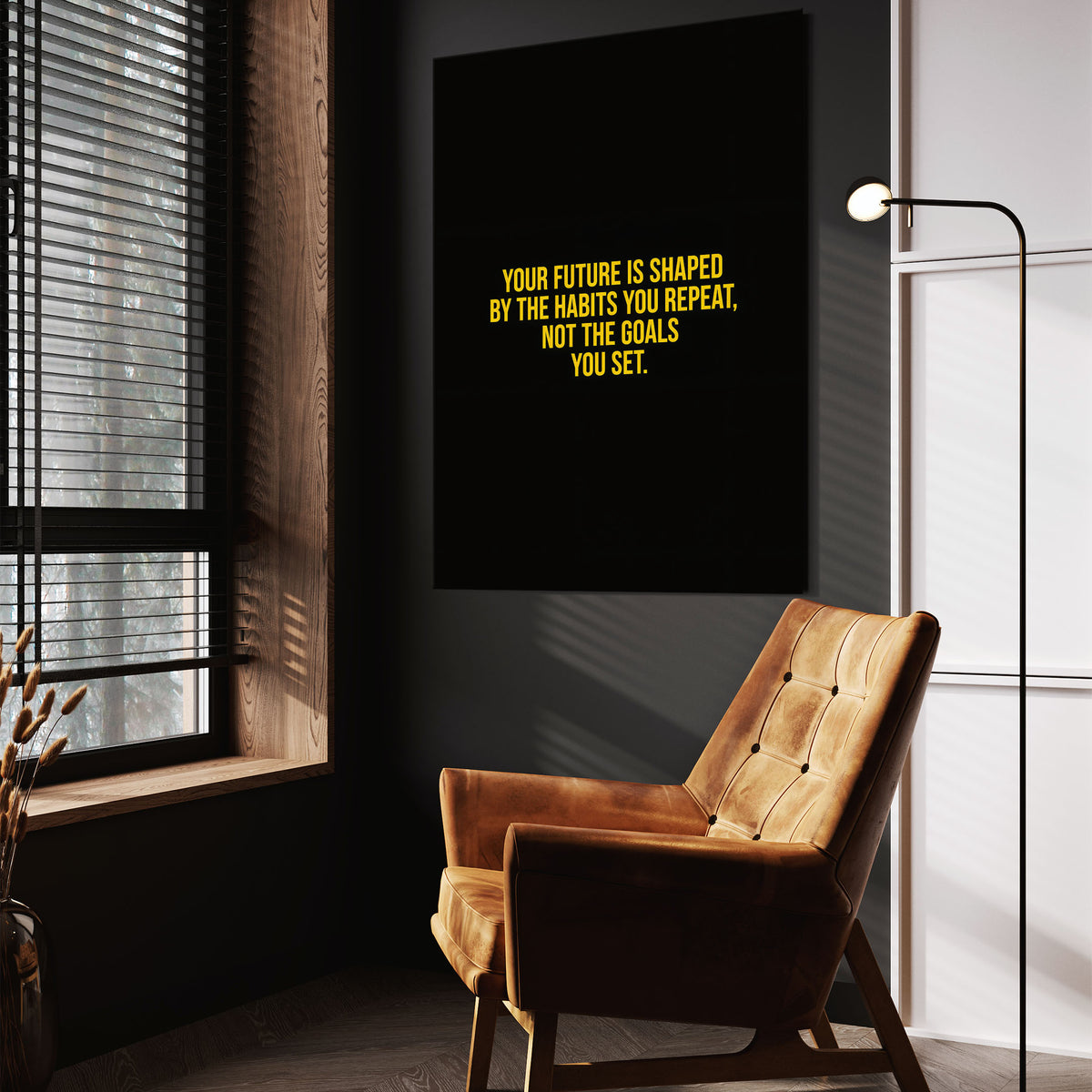 Habits Over Goals wall art above a wooden lounge chair in a dark room