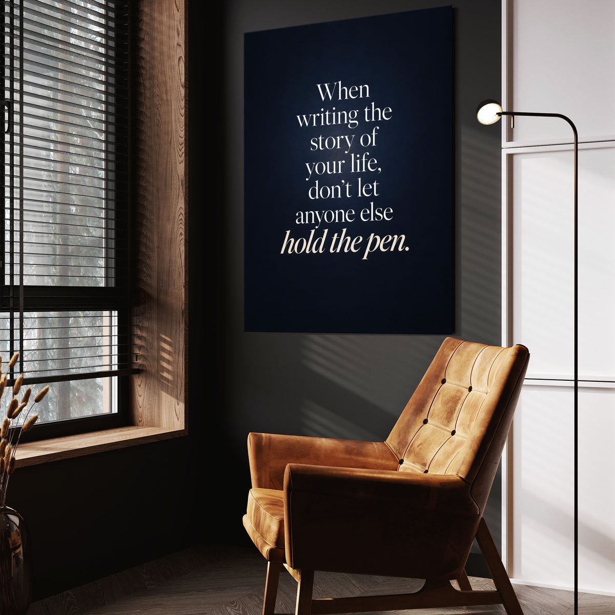 Hold The Pen wall art above a tan chair in a dark reading corner