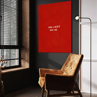 How Lucky Are We wall art above a wooden lounge chair in a dark room