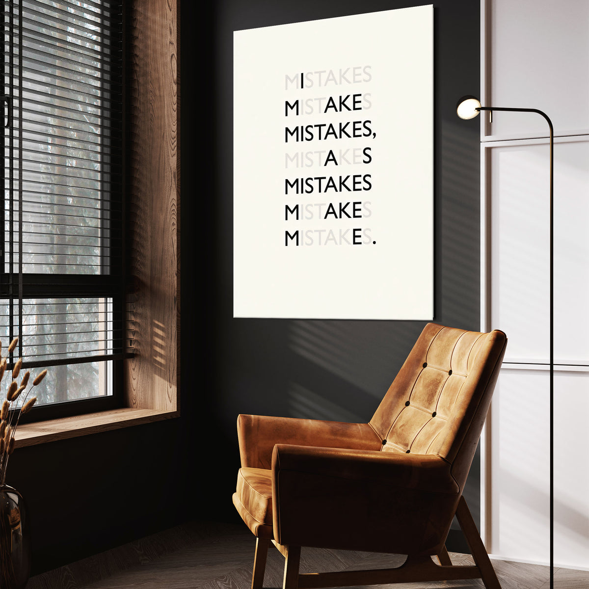 Mistakes wall art above a tan chair in a dark reading corner