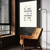 Mistakes wall art above a tan chair in a dark reading corner