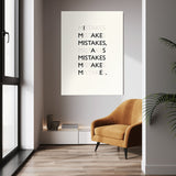 Mistakes wall art above a mustard chair in a bright room
