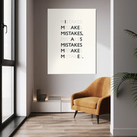 Mistakes wall art above a mustard chair in a bright room