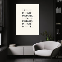 Mistakes wall art above a white chair in a dark room