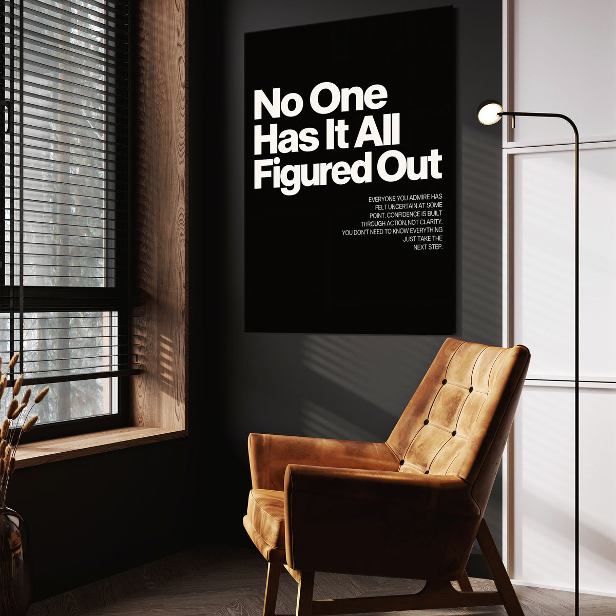 No One Has It All Figured Out wall art above a tan chair in a dark reading corner