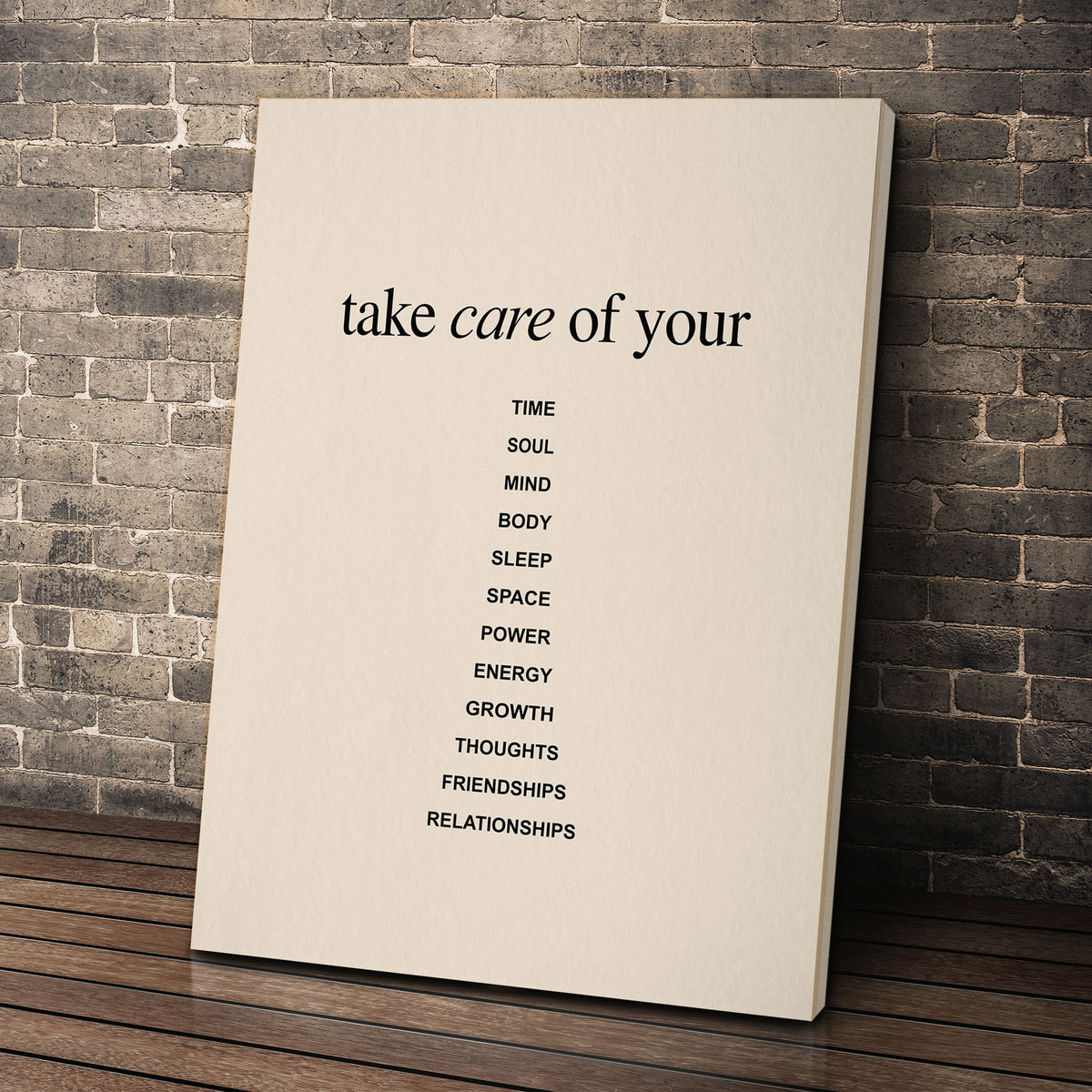 Take Care wall art leaning against a brick wall