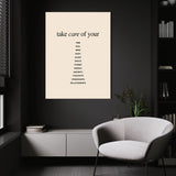 Take Care wall art above a white chair in a dark room