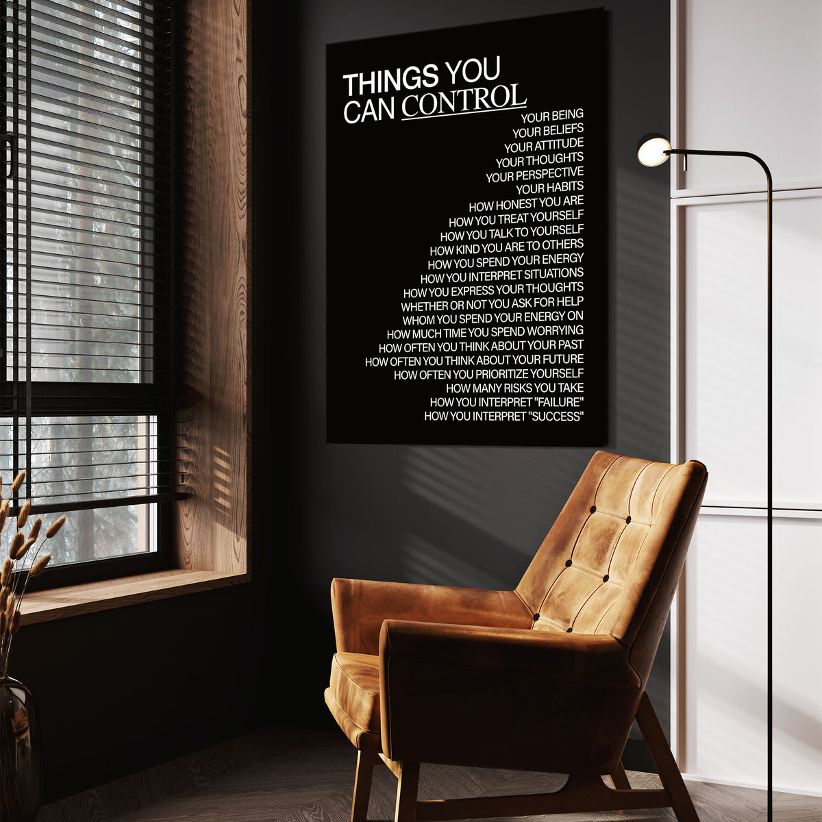 Things You Can Control (Black) wall art above a tan chair in a dark reading corner